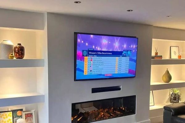 Built-in media wall with TV, fireplace, soundbar, and wall shelves
